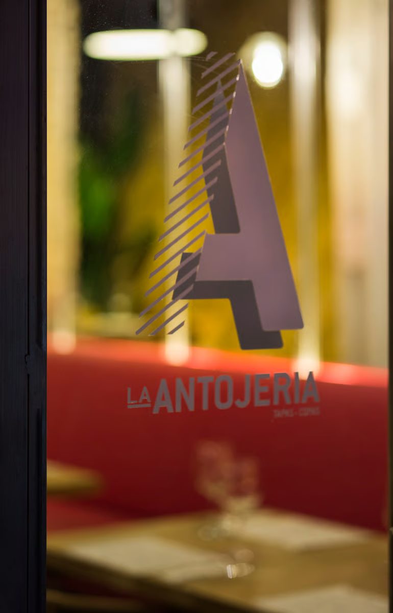 La A de La Antojería en el cristal